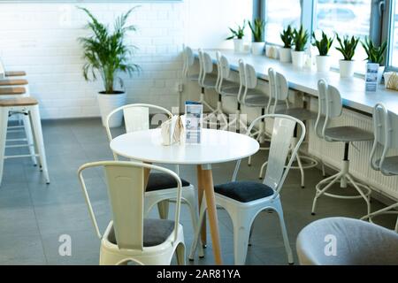 White round table and three chairs around on background of windowsill Stock Photo