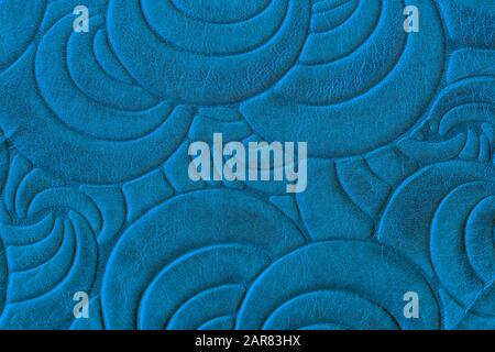 Texture of blue genuine leather close-up, with embossed spiral trend pattern. Fashionable background Stock Photo