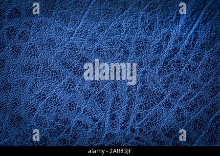 Texture of genuine leather close-up, surface close-up with wrinkles and cracks. Blue color, vintage design, trendy background witch vignette. Copy spa Stock Photo