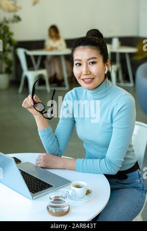 Young successful female student or freelancer sitting in front of laptop Stock Photo