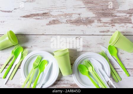 Plastic disposable dishes. Food plastic on wooden background top view. Recycling plastic and ecology concept. Plastic waste. Copy space. Stock Photo