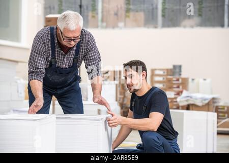 Examining stacks of printed newspapers Stock Photo