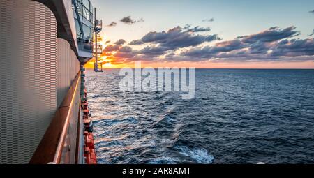 Seascape with cruise ship balcony side and sunset view on the horizon of the Caribbean Sea. Stock Photo