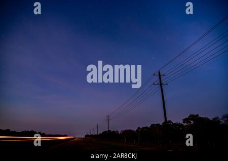 Wide Angle View of Early Sunrise On Country Road Road With Stars Visible in the Sky Stock Photo