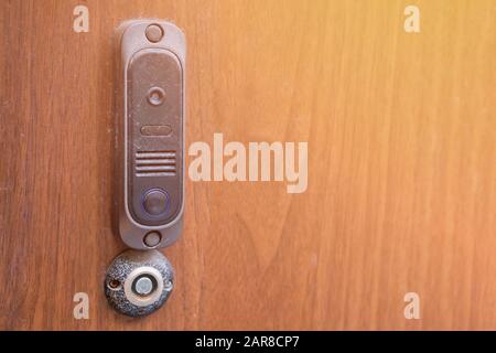 The modern intercom with a magnetic key space is mounted on a wooden wall. Close up. Stock Photo