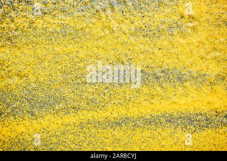 The plaster wall is painted with a yellow spray. Texture. Background Stock Photo