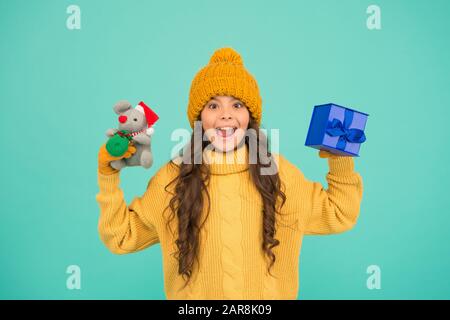 Taking two. child knitted clothes with toy rat. toy shop for kids. christmas is here. xmas winter holiday. happy new 2020 year. cute santa mice toy gift. small girl hold mouse toy and present box. Stock Photo