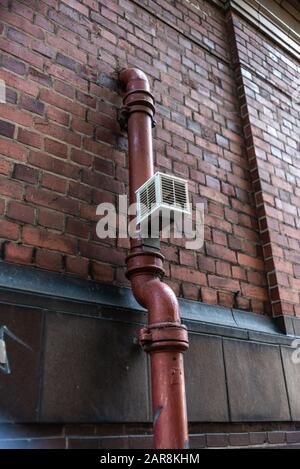 Old pipe brick wall valve vent painted rectangle Urban build texture modern uk city water gas Stock Photo