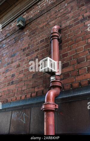 Old pipe brick wall valve vent painted rectangle Urban build texture modern uk city water gas Stock Photo