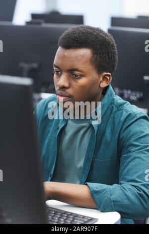 High angle portrait of African-American man using computer in class of college library, copy space Stock Photo