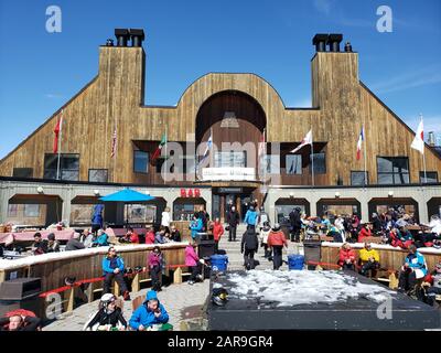 Saint-Sauveur, Canada - April 11, 2019: People seating outside at ski resort Sommet. Sommet Saint Sauveur is a ski resort in Quebec with lots of runs, Stock Photo