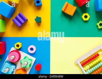 Wooden kids toys on colourful paper. Educational toys blocks. Toys for kindergarten, preschool or daycare. Copy space for text. Top view Stock Photo