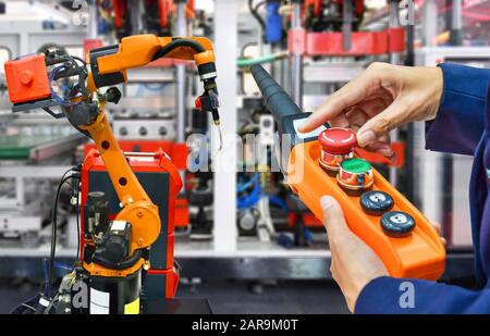 Engineer check and control modern high quality automation welding robots arm at industrial Stock Photo