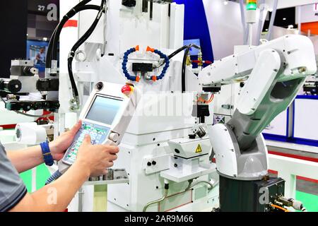Engineer check and control automation white Modern Robot Arm system in factory, Industry Robot concept . Stock Photo