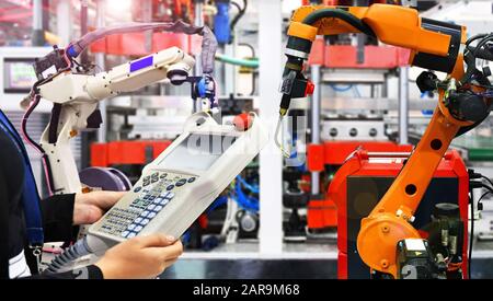Engineer check and control modern high quality automation welding robots arm at industrial Stock Photo