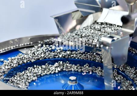 Many small bolts and nuts by manufacturing process in factory Stock Photo