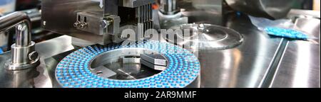 Blue capsule medicine pill production line, Industrial pharmaceutical concept. Stock Photo