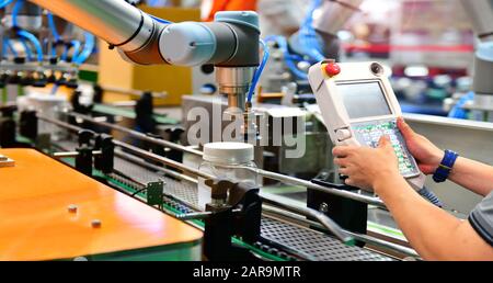 Engineer check and control automation robot arms arranged glass water bottle on Automatic industrial machinery equipment in production line factory Stock Photo