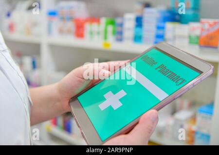 Doctor using computer tablet for search bar on display in pharmacy drugstore shelves background.Online medical concept. Stock Photo