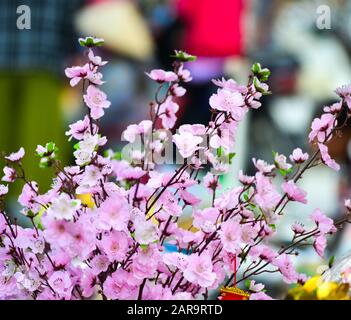 Selling artificial flowers for decoration at rural market in Vietnam. Stock Photo