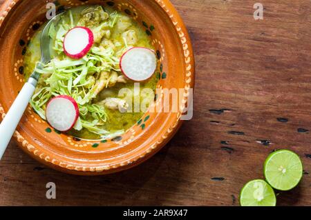 Pozole verde, or green posole is traditionally made with hominy and meat and topped with condiments. Mexican cuisine. Stock Photo