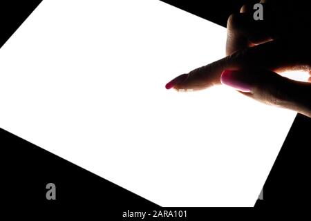 Tablet computer mockup in woman hand isolated on black background. Tablet laptop mockup with blank white screen at night. Empty space for text. Copy s Stock Photo