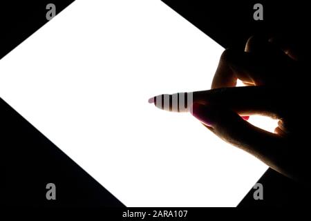 Tablet computer mockup in woman hand isolated on black background. Tablet laptop mockup with blank white screen at night. Empty space for text. Copy s Stock Photo