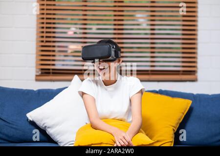 Young asian  woman  wearing virtual reality goggles. headset at home .future technology concept Stock Photo