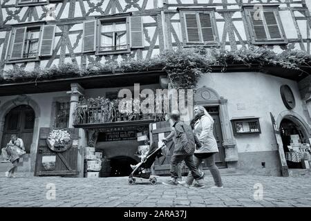 Man pushing pram, Cobbled Street, Riquewihr, Alsace, France, Europe Stock Photo