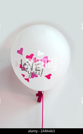 Pink hearts with the words LOVE you! on white balloon on white background Stock Photo