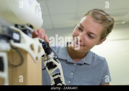 a woman fixing robotic arm Stock Photo