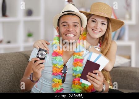 portrait of young couple holding passports and camera Stock Photo