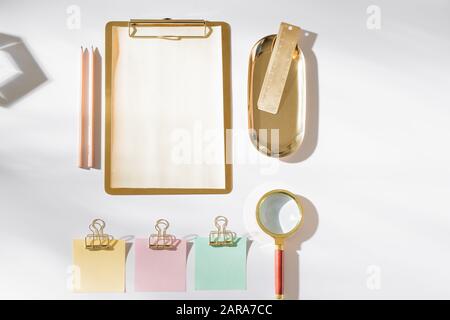 Styled working space with gold office supplies and color sticky note. Stock Photo