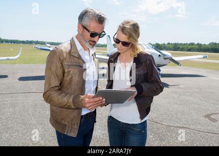 couple looking at tablet before flying Stock Photo