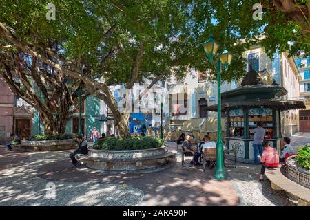 People sitting in the shade on historic Lilau Square (Largo do Lilau). Macau, China. Stock Photo