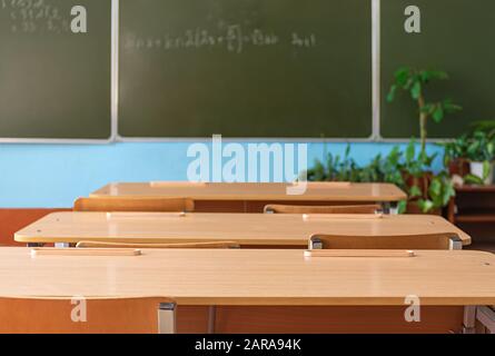 School empty classroom with school desks and blackboard in school. Back to school. Education concept. Stock Photo