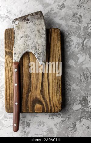 Old rustic axe for meat on a wooden board on grunge background. Food photography Stock Photo