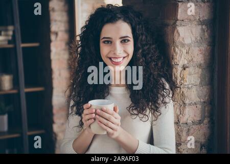 Close-up portrait of her she nice-looking attractive lovely charming cute cheerful cheery thoughtful wavy-haired girl drinking coffee in modern loft Stock Photo