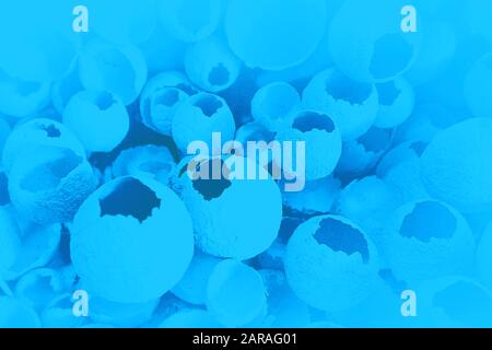 Cracked eggs pattern on classic blue color background. Top view, flat lay, selective focus. Easter creative minimal concept. Classic Blue color of the Year 2020 inscription. Stock Photo