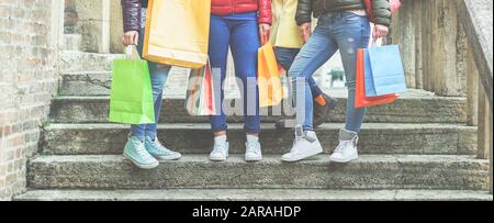 Young women with gift bags doing shopping -  Casual girls on stair case after buying clothes and female accessories in city shops center  - Sales conc Stock Photo