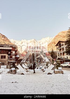 Courmayeur, Italy - January 18, 2020 Unrecognizable person takes a selfie in Courmayeur square with the background of snowy mountains Stock Photo