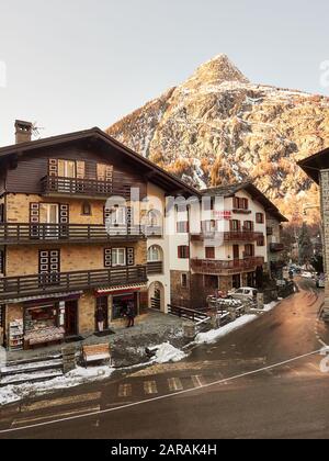 Courmayeur, Italy - January 18, 2020 View of one of the streets of the town of Courmayeur with the snowy mountains in the background during the day Stock Photo