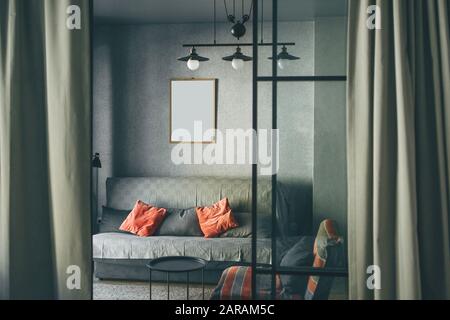 A cozy room in the Scandinavian style with the layout of the frame for paintings on the wall. Mock up paintings on the wall. Stock Photo