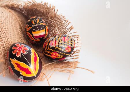 Traditional romanian hand painted easter eggs on rustic brown textured material isolated on white with copy text space Stock Photo