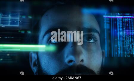 Close up of a young man eye controlling a futuristic computer system. Computer programmer coding on futuristic holographic display. Stock Photo
