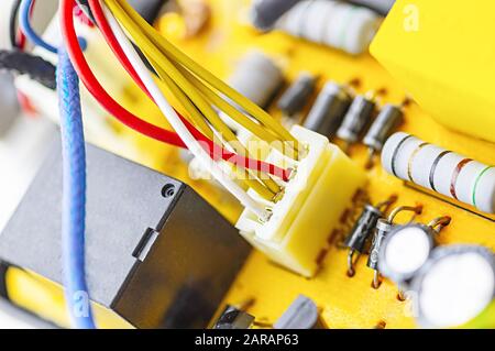 Power board for an electrical appliance. Multicolored electrical cables, condenser. Equipment repair concept. Selective focus. Close up. Stock Photo