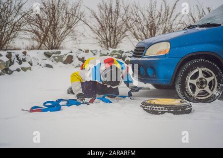 Man with towing rope hooks near towed car Stock Photo