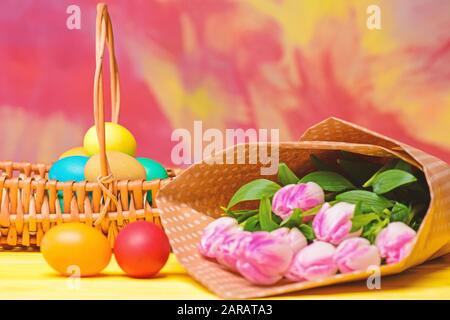 Spring holiday. Holiday celebration, preparation. Egg hunt. painted eggs in egg basket. Tulip flower bouquet. Healthy and happy holiday. Happy easter. Spring mood. Stock Photo