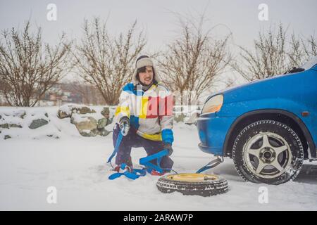 Man with towing rope hooks near towed car Stock Photo