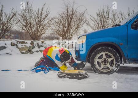 Man with towing rope hooks near towed car Stock Photo